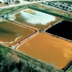 Aerial photo displaying four square ponds of brown and green water.